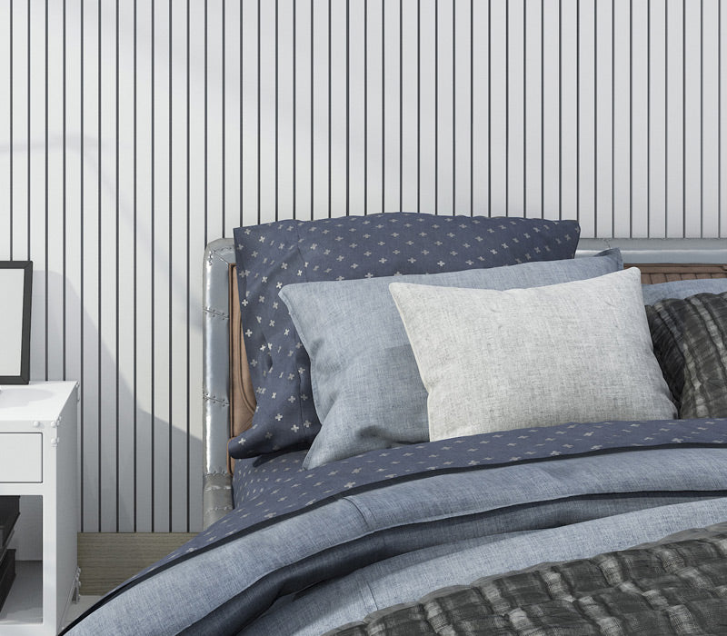 three blue and white billows sitting on bed